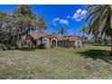 Beautiful single-story home with brick facade, manicured lawn, and mature shade trees at 12202 Rambling Oak Blvd, Orlando, FL 32832