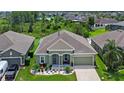 Aerial view of a well-maintained home with lush landscaping, a two-car garage, and surrounded by trees and other homes at 12289 Prairie Plantation Way, Orlando, FL 32824