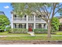 Charming two-story home with a red door, white columns, and a welcoming front porch at 13505 Phoenix Dr, Orlando, FL 32828