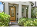 Inviting front entrance featuring a glass door, stylish lighting, and lush greenery at 1429 Indiana Ave, Winter Park, FL 32789