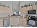 Kitchen featuring stainless steel appliances, neutral countertops, and a breakfast bar with views into the living room at 149 Acadia Dr, Kissimmee, FL 34759