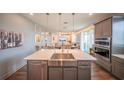 Open kitchen featuring a large island with a stainless steel sink, and pendant lighting at 1631 Pontiff Pl, Davenport, FL 33896