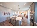 Open kitchen featuring a large island with a stainless steel sink, with an open floor plan at 1631 Pontiff Pl, Davenport, FL 33896