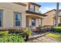 Charming condo entrance featuring a covered porch, detailed landscaping, and a well-maintained exterior at 202 Napoli Dr # 202, Davenport, FL 33897