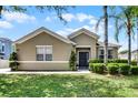 Inviting single-story home featuring manicured landscaping, green lawn, and neutral exterior paint at 2024 Beardsley Dr, Apopka, FL 32703