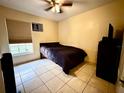 Simply decorated bedroom with tile floors, dark furnishings, and a window view at 2108 Shannon Lakes Blvd, Kissimmee, FL 34743