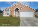 Inviting single-Gathering home featuring a two-car garage and simple landscaping at 2108 Shannon Lakes Blvd, Kissimmee, FL 34743