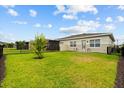 Spacious backyard features lush green grass, a black metal fence and a small area for outdoor seating at 2524 Datura Loop, St Cloud, FL 34772