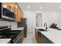 Modern kitchen features stainless steel appliances, wooden cabinetry, and a convenient layout at 2524 Datura Loop, St Cloud, FL 34772