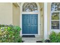 Inviting double front door with arched transom window and lush landscaping at 2598 Ekana Dr, Oviedo, FL 32765