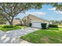 Charming single-story home features a well-manicured lawn, mature trees, and a two-car garage at 2598 Ekana Dr, Oviedo, FL 32765