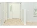 Bright foyer features neutral tile flooring, a coat closet, and natural light at 2828 Whispering Way, Winter Park, FL 32792