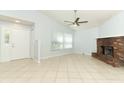 Spacious living room with a brick fireplace, ceiling fan, and tile flooring at 2828 Whispering Way, Winter Park, FL 32792