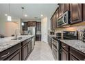 Close-up of gourmet kitchen featuring stainless appliances, granite countertops and herringbone floors at 2938 Bushmead Ct, Ocoee, FL 34761
