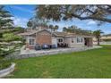 Charming single-story home with a brick facade, inviting patio, and lush green lawn at 434 S Beach St, Ormond Beach, FL 32174