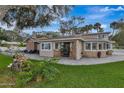 Charming single-story home with a brick facade, inviting patio, and lush green lawn at 434 S Beach St, Ormond Beach, FL 32174