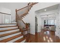 Elegant foyer featuring hardwood floors, a wooden staircase, and an open view into the living area at 4474 Enders St, Orlando, FL 32814