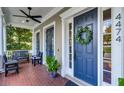 Inviting front porch with a blue door adorned with a wreath, flanked by sidelights and a bench at 4474 Enders St, Orlando, FL 32814