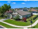 Landscaped home with a well-manicured lawn, mature trees, and a fenced yard, surrounded by other homes at 570 Cascading Creek Ln, Winter Garden, FL 34787