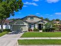 Charming home with an attached garage, a welcoming front porch, and manicured landscaping at 570 Cascading Creek Ln, Winter Garden, FL 34787