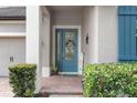 Close-up of a charming front entryway featuring a decorative blue door with sidelights and a colorful welcome sign at 604 Fosters Grove Loop, Oviedo, FL 32765