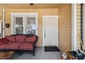 Inviting front porch featuring a comfortable wicker sofa with a red patterned cushion next to the front door at 706 Hillcrest St, Orlando, FL 32803