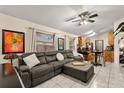 Spacious living room featuring a comfortable sectional, ceiling fan and lots of light at 7951 Chediston Cir, Orlando, FL 32817