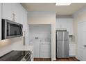 Well-organized kitchen features white cabinets, new appliances, and a convenient laundry closet at 8818 Villa View Cir # 304, Orlando, FL 32821