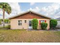 Charming one-story home with wood trim and well-kept landscaping and bright red shutters at 99 Rainbow Dr. # 4, Haines City, FL 33844