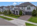 Attractive exterior view of a home with manicured landscaping and a paver driveway at 10742 Belle Maisons Dr, Orlando, FL 32832