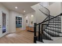 Inviting entryway featuring a curved staircase, leading to a library with built-in shelves at 10819 Savona Way, Orlando, FL 32827