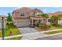 Charming two-story home features a two car garage, tile roof, front yard landscaping and brick paved drive at 1115 Oak Bluff Dr, Davenport, FL 33837