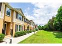 Townhome exteriors line a beautifully landscaped green space under a bright sky at 1255 Marley Ln, Winter Springs, FL 32708