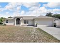 Charming single-story home featuring stucco siding, a two-car garage, and landscaped front yard at 1312 Catalina Blvd, Deltona, FL 32725