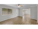 Bright living room with neutral walls, ceiling fan, wood-look flooring, and large window at 136 Blue Point Way # 320, Altamonte Springs, FL 32701