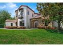 Lovely home features a stone archway, balcony, and professionally landscaped front yard at 1401 Green Cove Rd, Winter Park, FL 32789