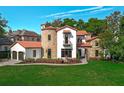 Charming two-story home boasts a stone turret, red tile roof and well-maintained lawn at 1401 Green Cove Rd, Winter Park, FL 32789