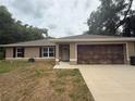 Inviting single-story house boasting a tidy front yard and an attached two-car garage at 14598 Se 28Th Ct, Summerfield, FL 34491