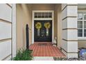 Close-up of the front door with yellow wreaths and a charming goose statue on the porch at 14848 Bonnybridge Dr, Orlando, FL 32826