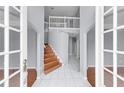 Bright foyer featuring wood and tile flooring and a staircase leading to the upper level at 1802 Imperial Palm Dr, Apopka, FL 32712