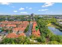 Aerial view of a beautiful community with lush greenery, a pond, and well-maintained townhomes at 1942 Michael Tiago Cir, Maitland, FL 32751