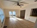 Bright living room with tile flooring, a ceiling fan, and sliding glass doors to outdoor space at 1985 Japonica Rd, Winter Park, FL 32792