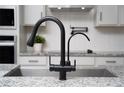 Close-up of a modern faucet and sink with granite countertop details at 2591 Seagirt Way, Clermont, FL 34711
