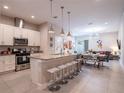 Open-concept kitchen with granite countertops, stainless steel appliances, and island seating at 2660 Sunrise Shores Dr, Kissimmee, FL 34747