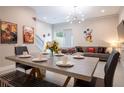 Open-concept living area featuring a modern chandelier, comfortable sofa, and themed artwork at 2660 Sunrise Shores Dr, Kissimmee, FL 34747