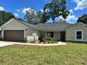 Charming single-story home featuring a well-maintained lawn and an attached two-car garage at 3082 Se 140Th Ln, Summerfield, FL 34491