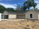 Newly constructed home with an attached garage, neutral stucco exterior and stone foundation at 3082 Se 140Th Ln, Summerfield, FL 34491