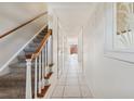 Bright hallway featuring tile flooring, a staircase, and white walls leading to the rest of the house at 316 Georgetown Dr # 316, Casselberry, FL 32707