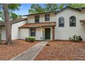Charming two-story townhome featuring a welcoming front entrance and well-maintained landscaping at 4045 Crossroads Pl, Casselberry, FL 32707