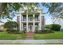 Elegant brick home with prominent white columns, black shuttered windows, and manicured lawn at 506 Golfpark Dr, Celebration, FL 34747
